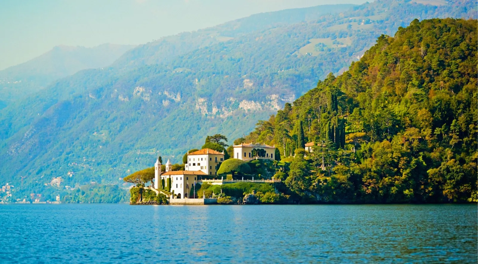 A villa on a wooded promontory jutting into the still waters of Lake Como