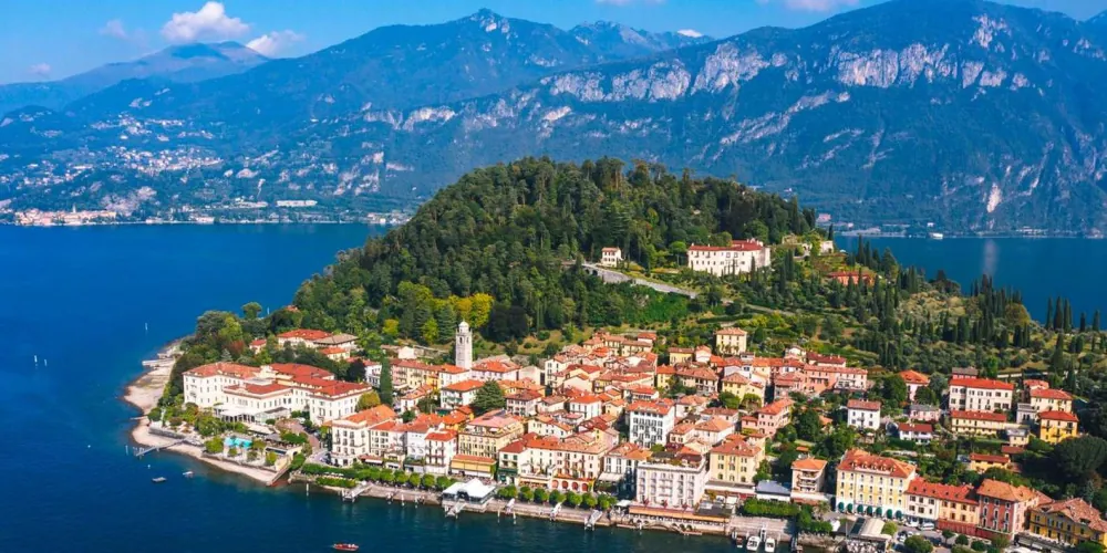 Aerial view of Bellagio village on its wooded promontory between the arms of Lake Como