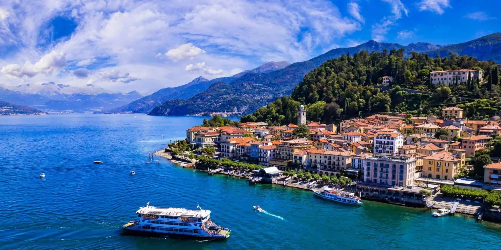 Lake Como's blue water and mountain shoreline seen from a cruise boat
